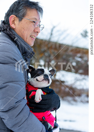 一名男子和他的狗在雪地裡玩耍 124106332