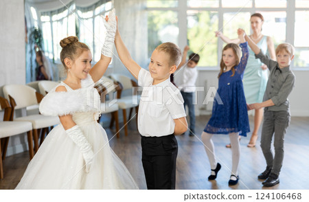Little children in elegant dresses practicing waltz dance in school hall Little children in elegant dresses practicing waltz dance in school hall 124106468