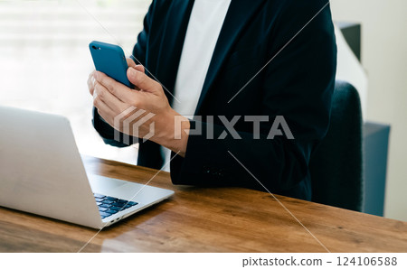 一個操作電腦和智能手機的人 一個操作電腦和智能手機的人 124106588