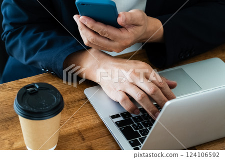 A man who operates a computer and a smartphone A man who operates a computer and a smartphone 124106592