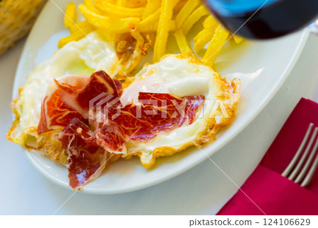 Spanish fried eggs with potatoes, ham and wine Spanish fried eggs with potatoes, ham and wine 124106629