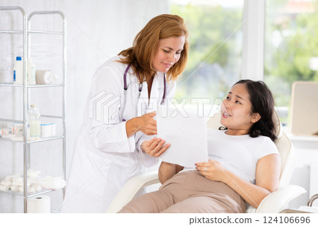 Female patient signs the contract for the operation in clinic of body aesthetics Female patient signs the contract for the operation in clinic of body aesthetics 124106696