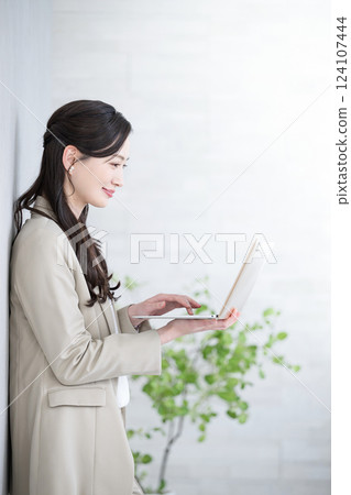Profile of a beautiful woman in a suit typing on a laptop computer. Job change, recruitment, human resources, consultant 124107444
