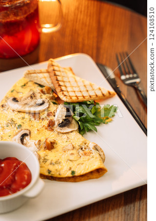 Omelette for breakfast with champignons and sauce Omelette for breakfast with champignons and sauce 124108510