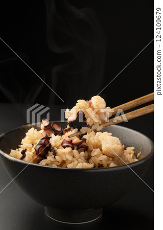Picking up freshly cooked steaming octopus rice with chopsticks 124109679