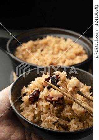 用筷子夾起剛煮好熱氣騰騰的章魚飯 用筷子夾起剛煮好熱氣騰騰的章魚飯 124109681