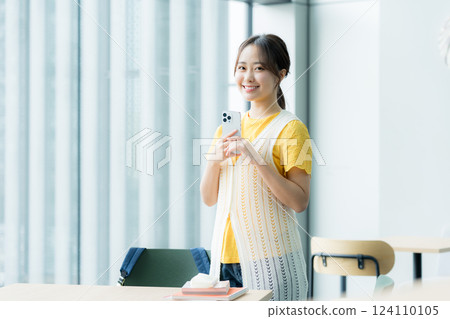 A student looking at a smartphone in a cafe 124110105