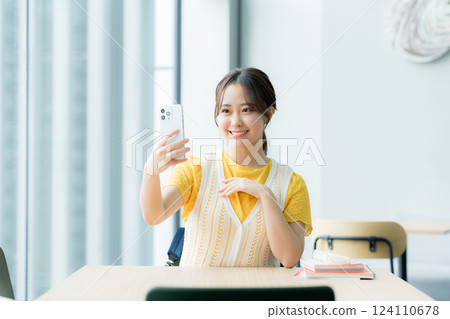 A student looking at a smartphone in a cafe A student looking at a smartphone in a cafe 124110678