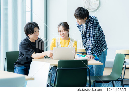 Students talking while looking at a computer Students talking while looking at a computer 124110835