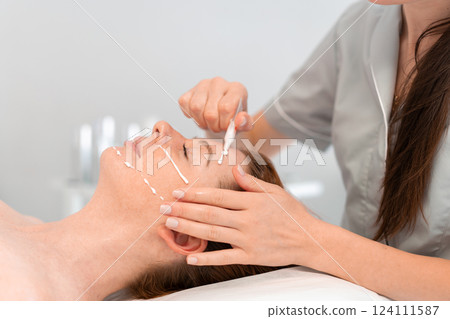 Dermatologist applying cream on woman face in Dermatologist applying cream on woman face in 124111587