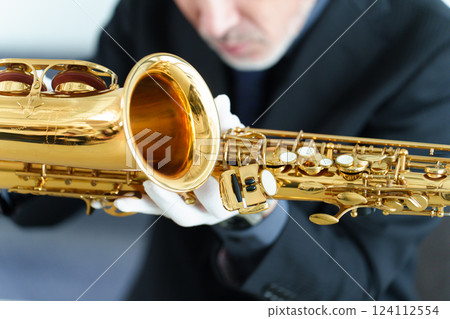 A man performing maintenance on a saxophone 124112554