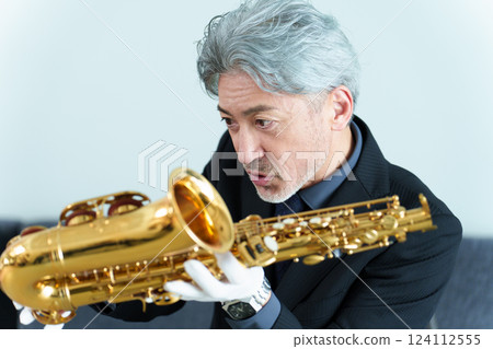 A man performing maintenance on a saxophone 124112555