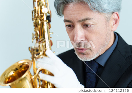 A man performing maintenance on a saxophone 124112556