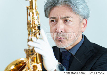 A man performing maintenance on a saxophone 124112557