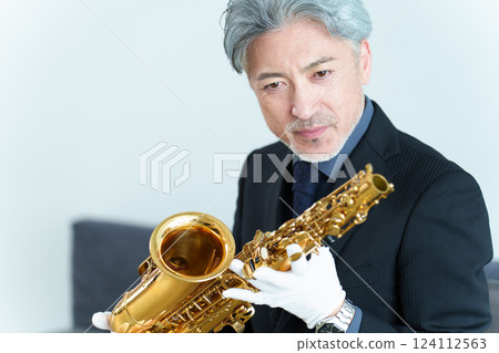 A man performing maintenance on a saxophone 124112563