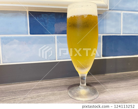 Draft beer in a glass, golden beer with a head of foam. Draft beer in a glass, golden beer with a head of foam. 124113252