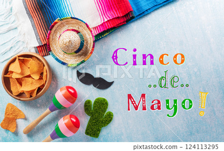 Cinco de Mayo holiday background made from maracas, mexican blanket stripes or poncho serape and hat on blue background. 124113295