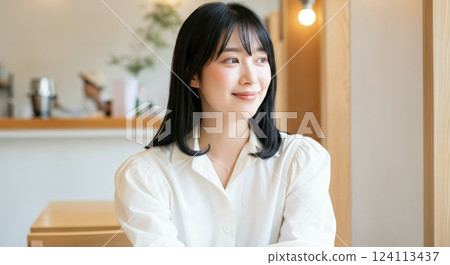 Asian female adult in relaxed cafe setting with modern interior for lifestyle and cultural themes 124113437