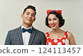 Retro-themed portrait of smiling young adult hispanic couple in vintage attire 124113457