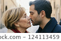 Intergenerational connection: caucasian mature woman and hispanic young man sharing a tender moment in an urban setting 124113459