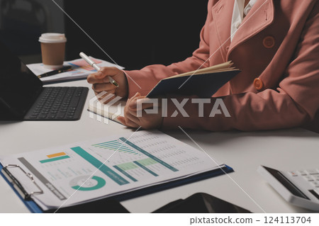 Cropped image of professional businesswoman working at her office via laptop, young female manager using portable computer device while sitting at modern loft, flare light, work process concept 124113704