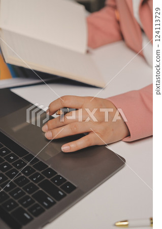Cropped image of professional businesswoman working at her office via laptop, young female manager using portable computer device while sitting at modern loft, flare light, work process concept Cropped image of professional businesswoman working at her office via laptop, young female manager using portable computer device while sitting at modern loft, flare light, work process concept 124113729