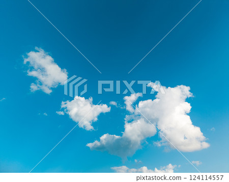 white clouds drift across a bright blue summer sky 124114557