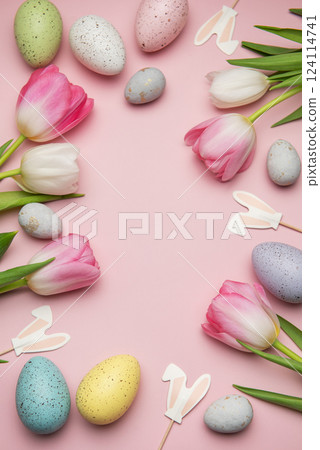 Easter eggs and pink tulips creating a frame on a pink background Easter eggs and pink tulips creating a frame on a pink background 124114741