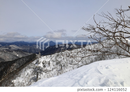 Hokkaido Daisetsuzan mountain range: View of the summit of Mt. Mikuni and the mountains towards the Tokoro River from the Oiwa water point in Hokkaido in winter 124116052