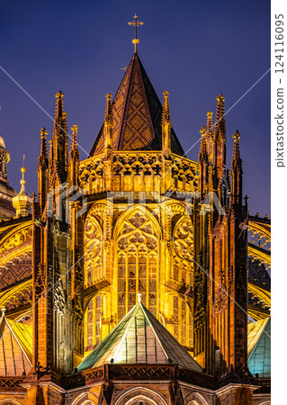 Stunning ornamental details illuminate the backside of St Vitus Cathedral at Prague Castle. The intricate designs showcase gothic artistry against the evening sky. 124116095