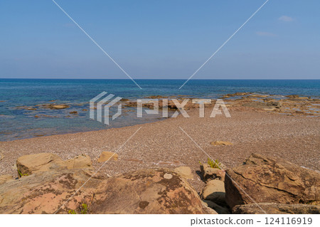 Peaceful Mediterranean Beach with Rocky Shoreline 124116919