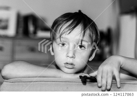 Pensive Child Resting on Couch in Black and White 124117863
