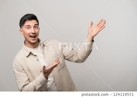 Exciting product or service presentation as a handsome man in his 30s with a big smile confidently points up and to the side with open palms, radiating happiness and trust Exciting product or service presentation as a handsome man in his 30s with a big smile confidently points up and to the side with open palms, radiating happiness and trust 124119551