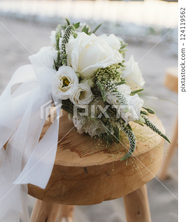 Elegant Bridal Bouquet on Wooden Stool at Outdoor Wedding Elegant Bridal Bouquet on Wooden Stool at Outdoor Wedding 124119562