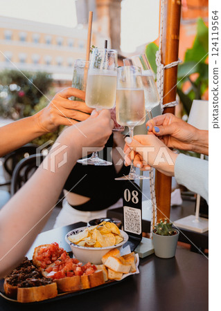 Celebratory Toast with Glasses and Appetizers on Table 124119564