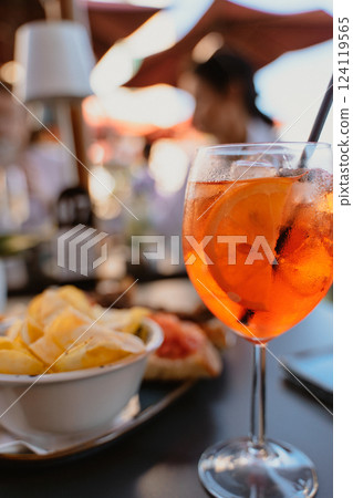 Refreshing Aperol Spritz with Snacks at Outdoor Cafe 124119565
