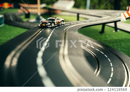 Miniature Race Car on Toy Track with Curved Road Miniature Race Car on Toy Track with Curved Road 124119569