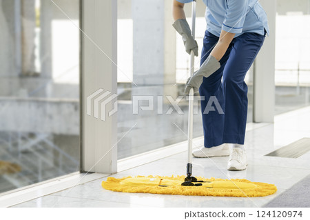 Building cleaning image: The hands of a female cleaning staff member wiping the floor with a mop Building cleaning image: The hands of a female cleaning staff member wiping the floor with a mop 124120974
