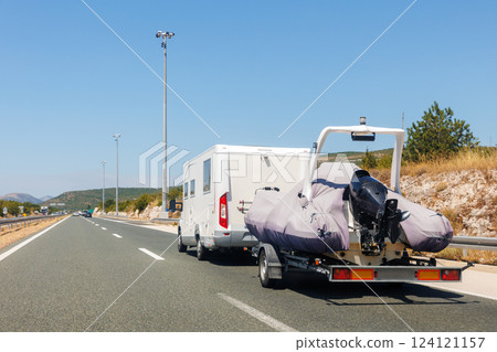 Modern luxury SUV towing yacht boat trailer carrier go river lake sea vacation mountain highway road summer light. Luxury rich fishing leisure recreation lifestyle. Service maintenance transportation Modern luxury SUV towing yacht boat trailer carrier go river lake sea vacation mountain highway road summer light. Luxury rich fishing leisure recreation lifestyle. Service maintenance transportation 124121157
