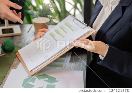 Data Analysis and Environmental Impact. A businesswoman reviewing sustainability reports, focusing on ecological data in professional settings. Data Analysis and Environmental Impact. A businesswoman reviewing sustainability reports, focusing on ecological data in professional settings. 124121878