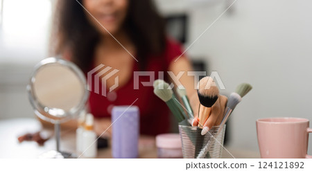 Makeup Tools and Natural Beauty. A collection of makeup brushes and skincare products displayed on a table, symbolizing a beauty routine. 124121892