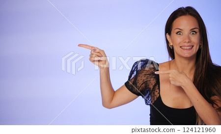 Excited beauty blogger pointing to the side with a big smile  124121960