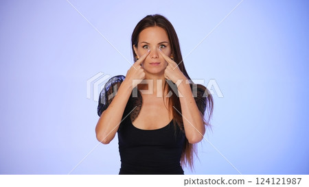 Woman demonstrating facial yoga for eye area  124121987