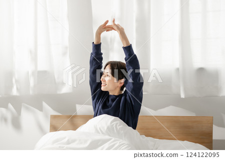 A woman stretching in bed 124122095