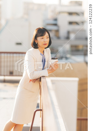 A middle-career woman thinking alone while facing a wall 124122239
