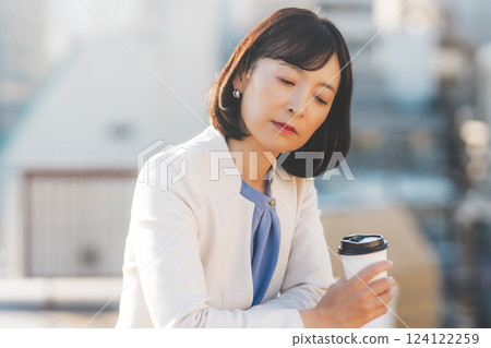 一位中年女性獨自面對牆壁思考 一位中年女性獨自面對牆壁思考 124122259