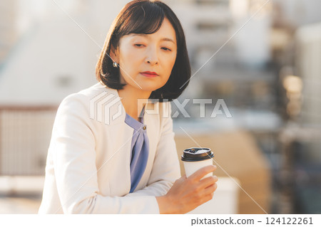 A middle-career woman thinking alone while facing a wall A middle-career woman thinking alone while facing a wall 124122261