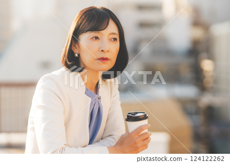 A middle-career woman thinking alone while facing a wall A middle-career woman thinking alone while facing a wall 124122262