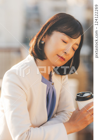 A middle-career woman thinking alone while facing a wall 124122269