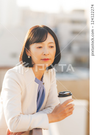A middle-career woman thinking alone while facing a wall A middle-career woman thinking alone while facing a wall 124122274